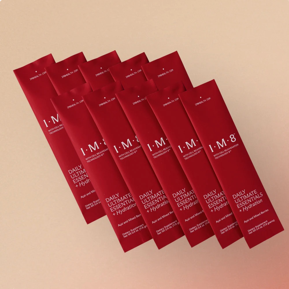 Nine red packets labeled "I·M·8 Daily Ultimate Essentials Hydration" are arranged diagonally on a beige background.