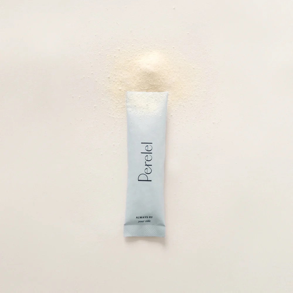 A single-serve packet labeled "Perelel" lies on a white surface with its powder contents spilled around the top.