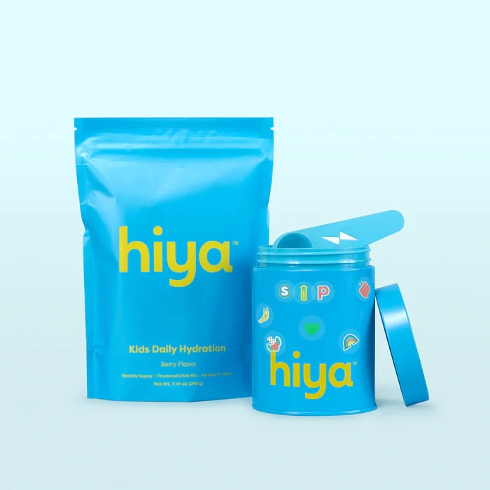 A blue pouch and container labeled "hiya" for kids daily hydration, berry flavor, with colorful stickers and a matching blue scoop inside.