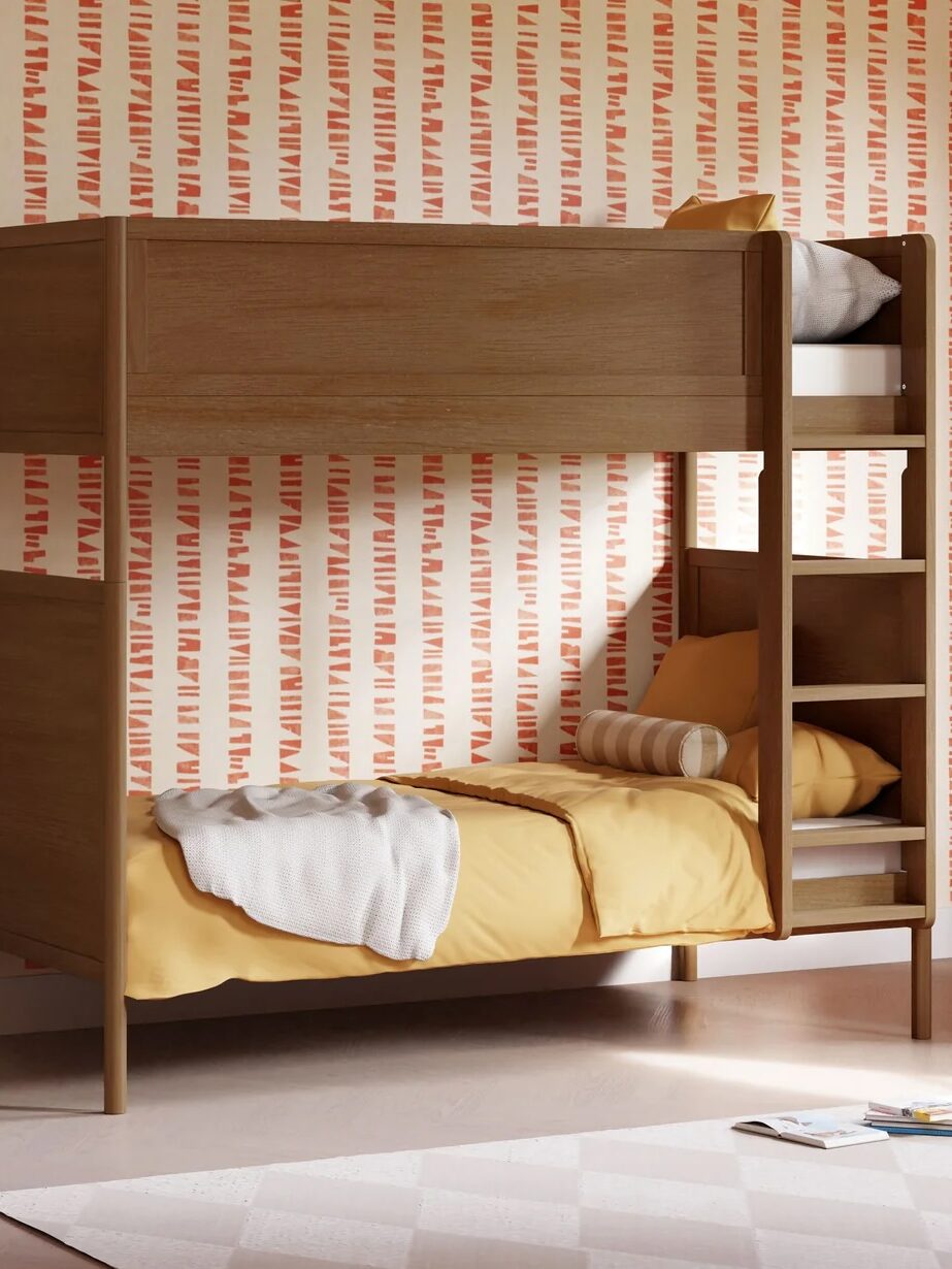 Wooden bunk bed with yellow bedding and a ladder, set against a patterned orange and white wall in a modern bedroom.