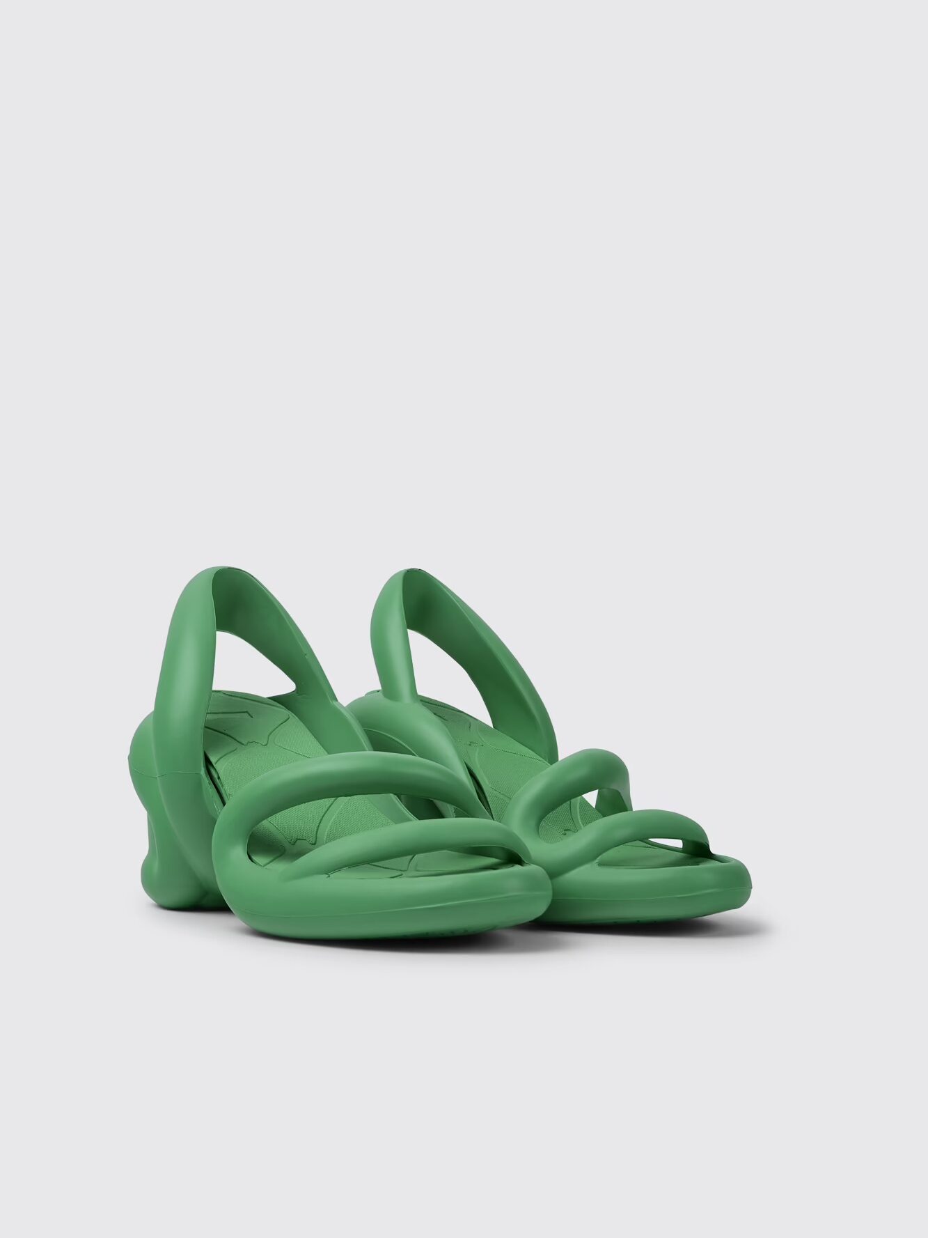 A pair of green, open-toe, sculptural sandals with thick, rounded straps and a chunky heel, displayed against a plain light background.