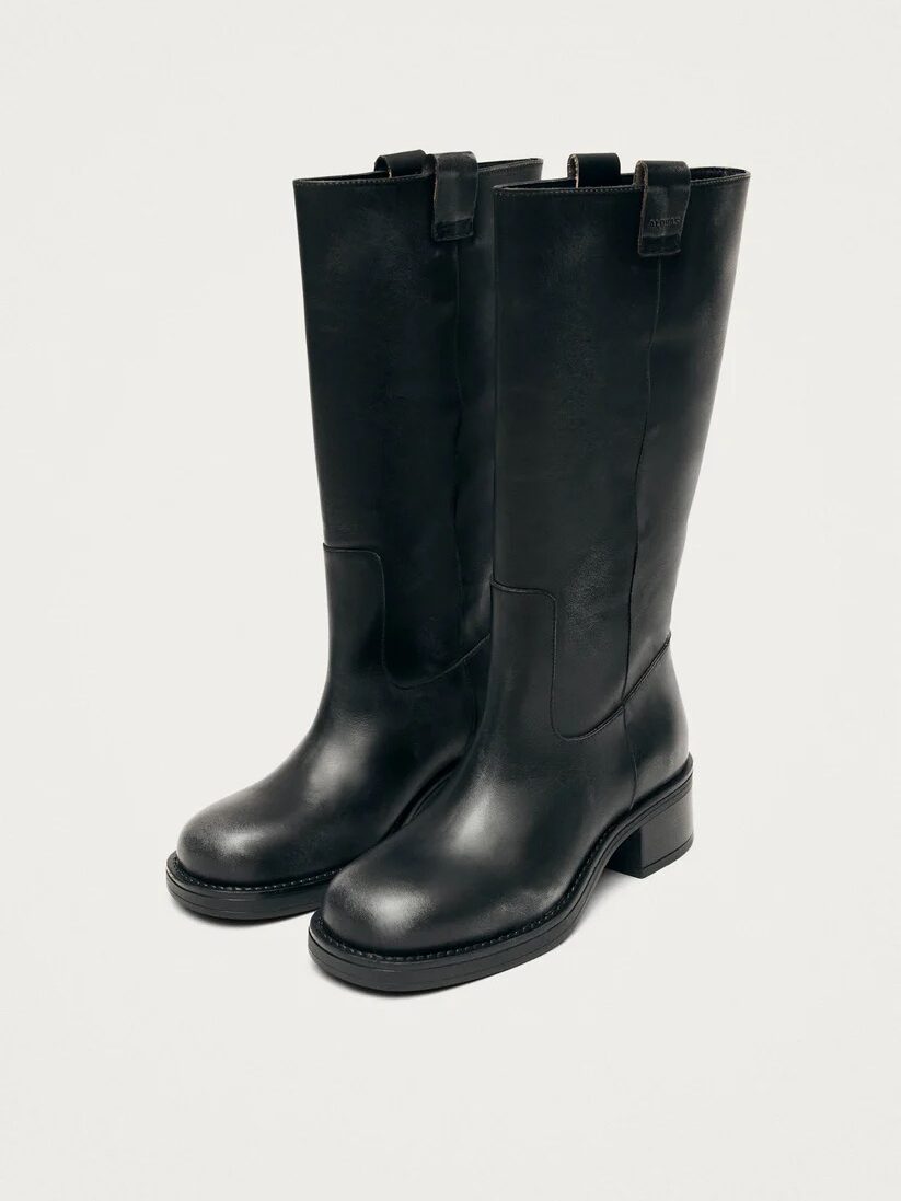 A pair of black, mid-calf leather boots with low block heels and pull tabs, displayed on a plain light background.