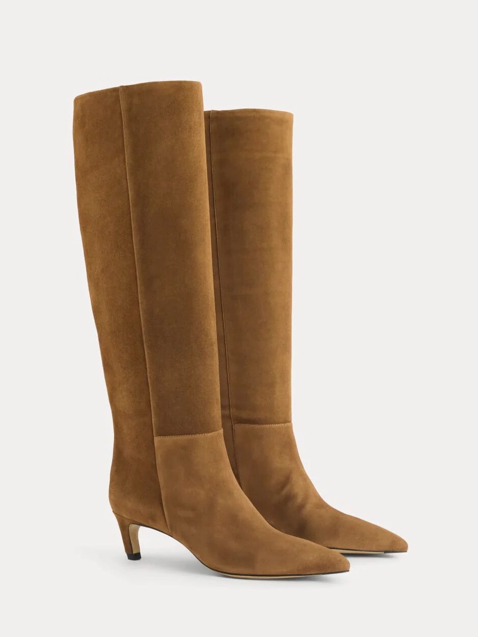A pair of tan suede knee-high boots with a low, thin heel and pointed toes, shown against a plain background.