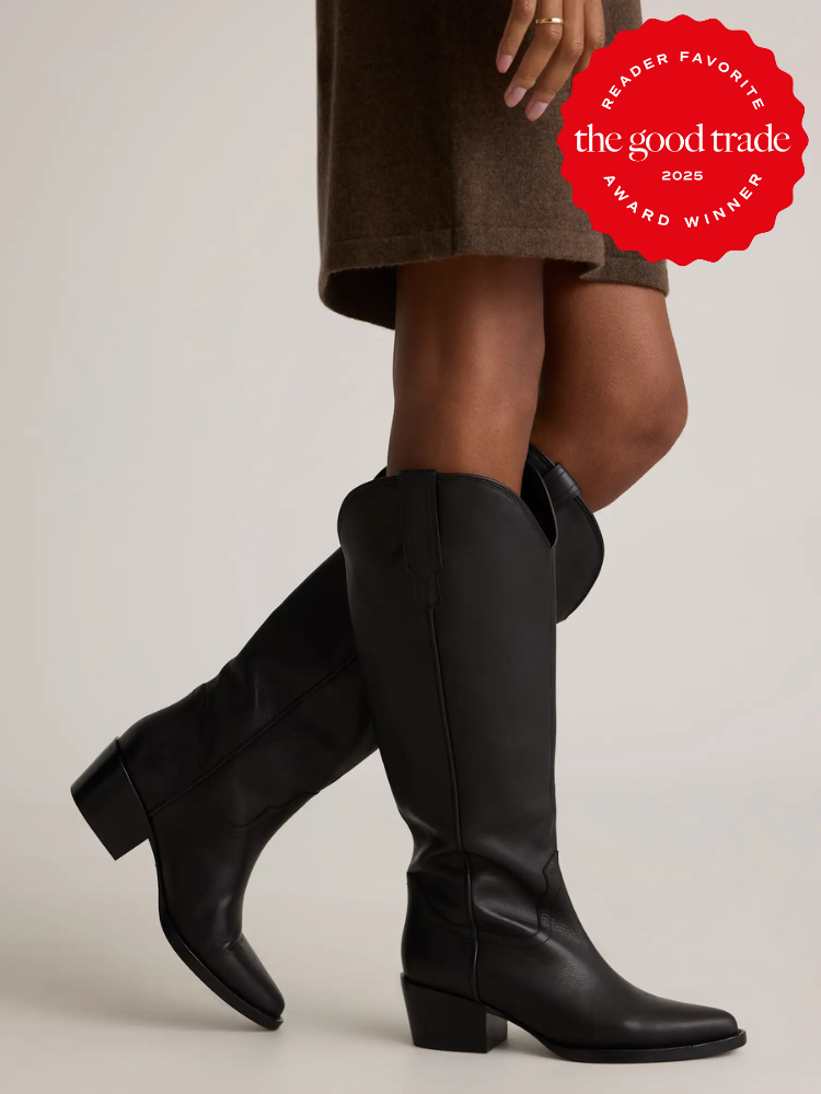 A person wearing black knee-high boots and a brown skirt stands against a plain background. A red badge in the corner reads “the good trade award winner 2025.”.