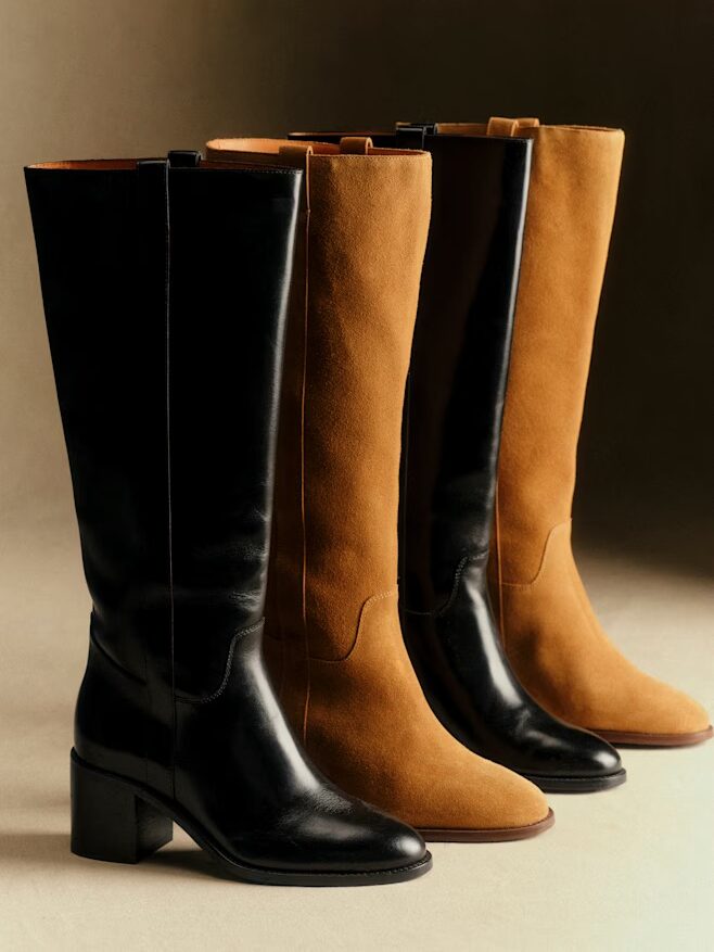 Four knee-high boots are displayed upright, with two in black leather and two in tan suede, all featuring low block heels, against a neutral background.