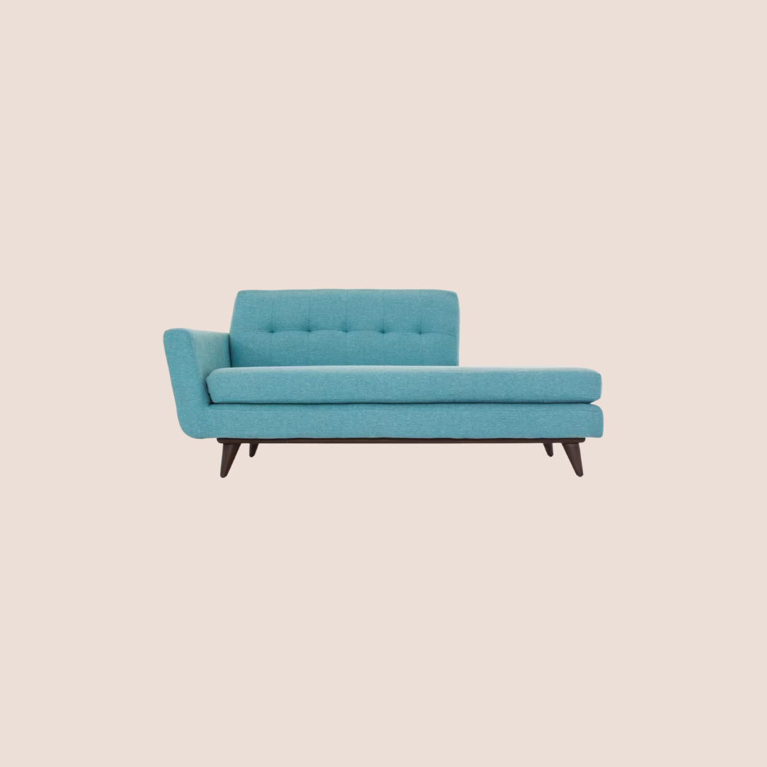 A modern teal upholstered chaise lounge with wooden legs, featuring a left-side armrest and a tufted backrest, set against a plain light background.