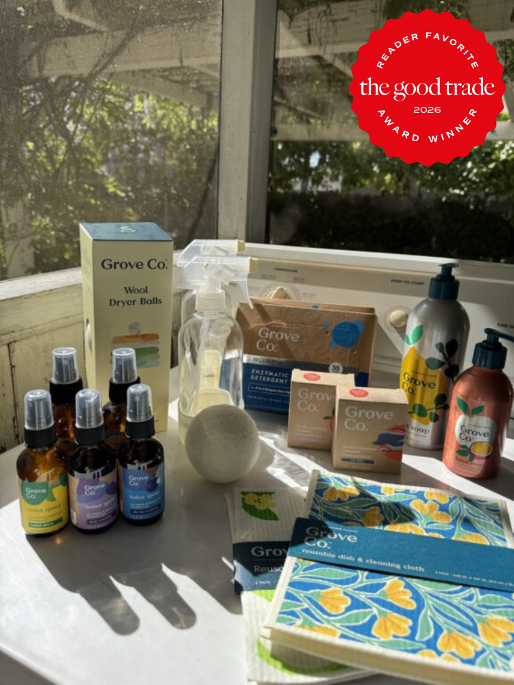 A collection of Grove Co. eco-friendly cleaning and laundry products displayed on a sunlit surface, with a red "The Good Trade 2026 Reader Favorite Award Winner" badge in the corner.