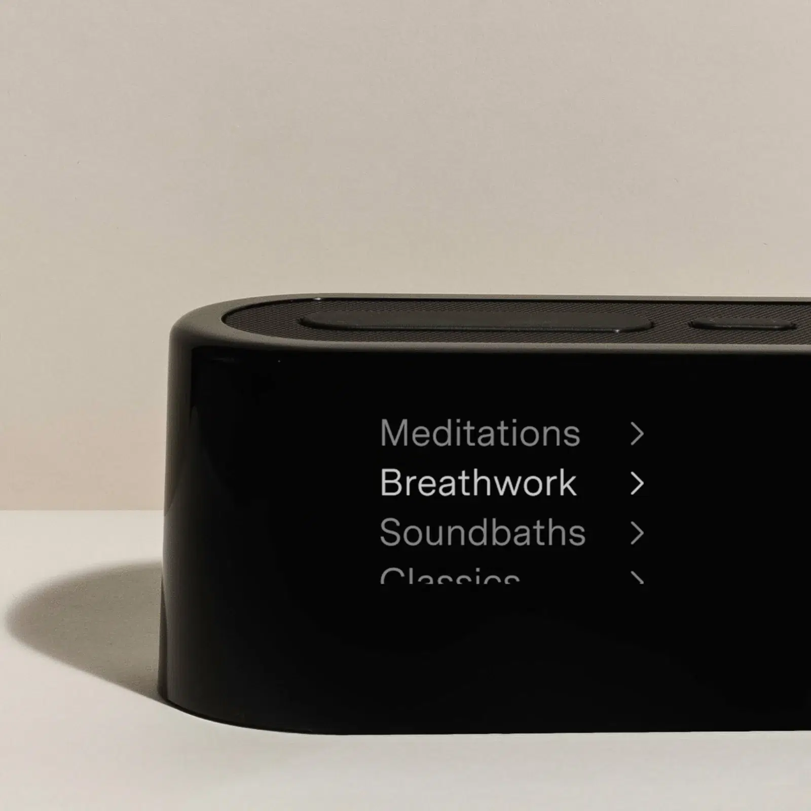 A black electronic device displays a menu with options: Meditations, Breathwork, Soundbaths, and Classics. The "Breathwork" option is highlighted.
