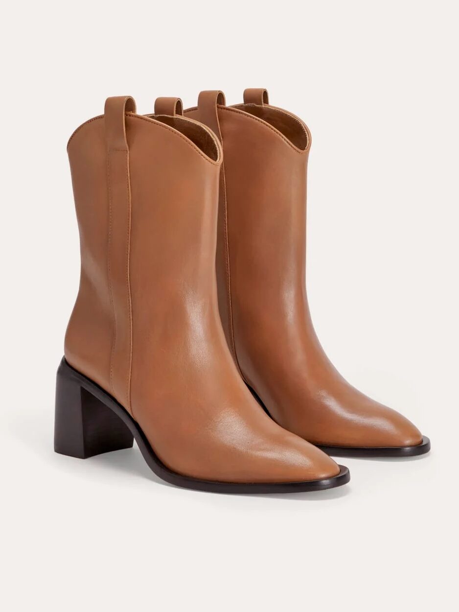 A pair of light brown leather ankle boots with pointed toes and block heels, displayed on a neutral background.