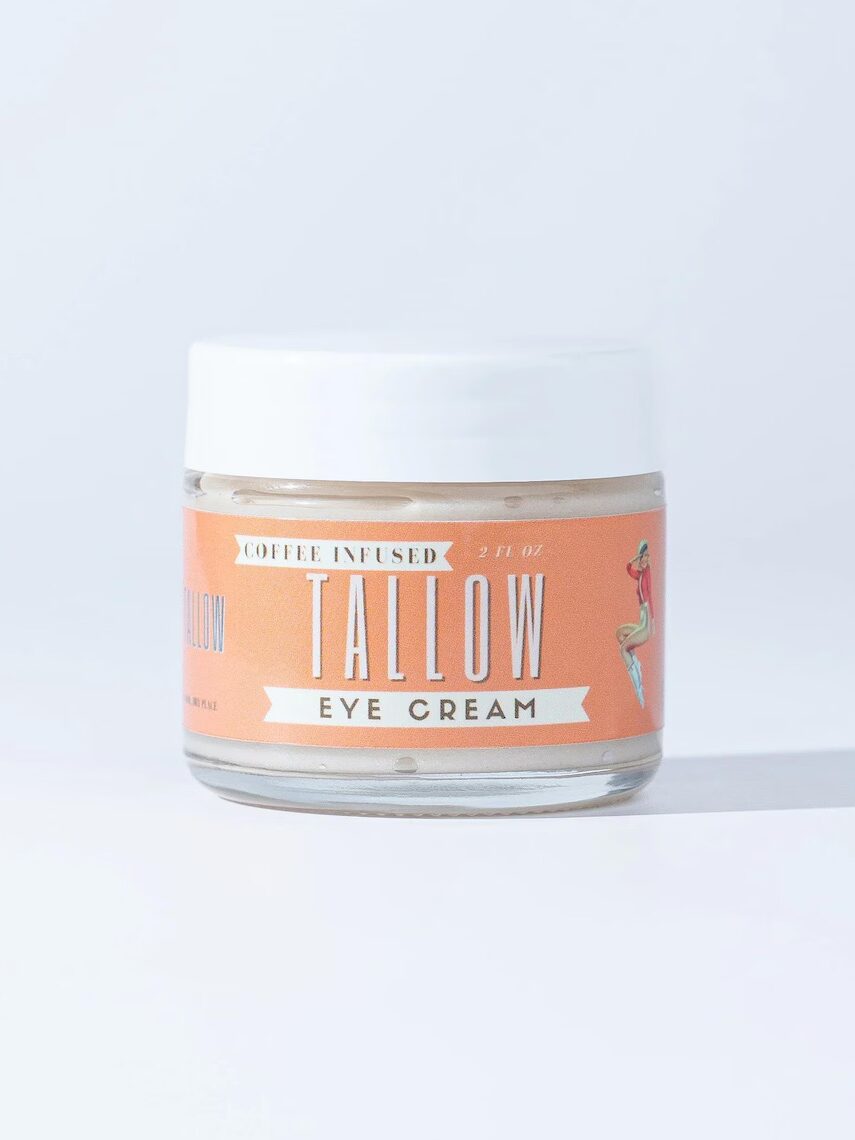 A small glass jar labeled "Coffee Infused Tallow Eye Cream" with a white lid, displayed against a light background.